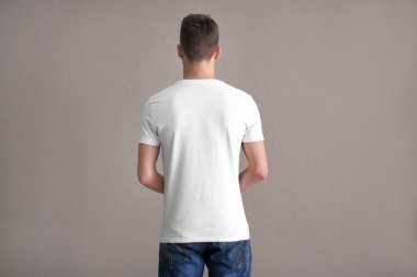 Genç adam t-shirt üzerinde ışık arka plan renk. Mockup tasarım için