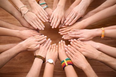 İnsanlar ellerini birlikte ahşap masada birlik sembolü olarak koyarak.