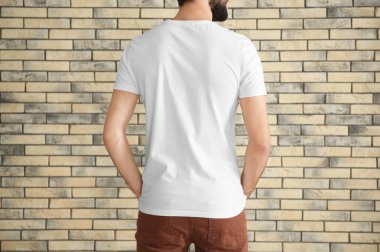 Duvara karşı şık tişört genç adam. Mockup tasarım için