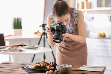 Genç kadın mutfakta natürmort fotoğraf çekmeye profesyonel kamera ile