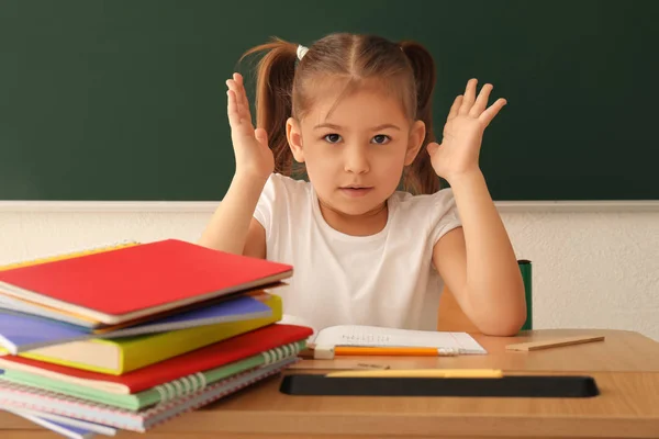Malá holčička nechce dělat úkoly v učebně — Stock fotografie