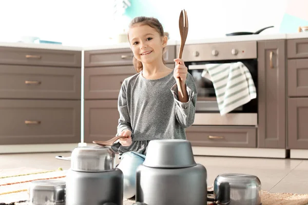 Söt liten flicka som leker med köksutrustning som trummor inomhus — Stockfoto