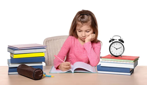 Carino bambina facendo i compiti contro sfondo bianco — Foto Stock