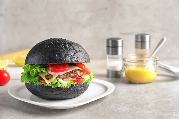 Hambúrguer saboroso com pão preto — Fotografia de Stock