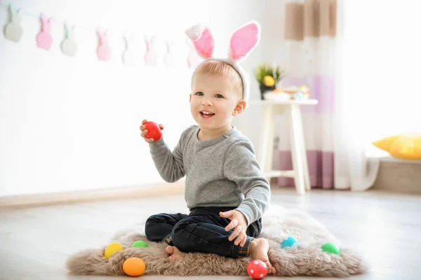 Χαριτωμένο μικρό αγόρι με τα αυτιά λαγουδάκι, κρατώντας το αυγό του Πάσχα σε εσωτερικούς χώρους — Φωτογραφία Αρχείου