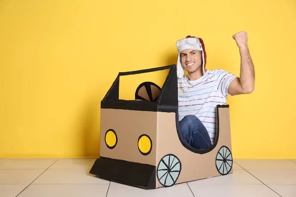 Молодой Человек Играет Картонным Авто Возле Цветной Стены Концепция Покупки — стоковое фото