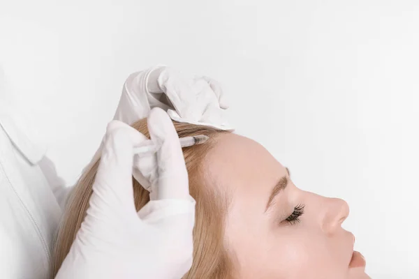 Mulher jovem com problema de cabelo recebendo injeção em fundo claro, close-up — Fotografia de Stock