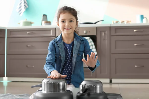 Симпатична маленька дівчинка грає з посудом як барабани на кухні — стокове фото