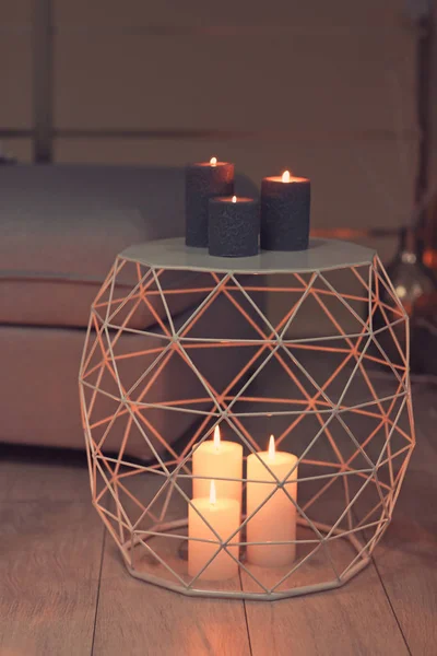 Brennende Kerzen auf Fußboden und Tisch drinnen — Stockfoto
