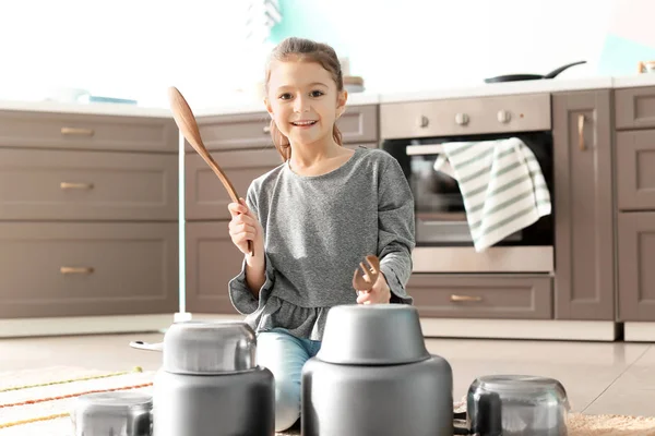 Söt liten flicka som leker med köksutrustning som trummor inomhus — Stockfoto