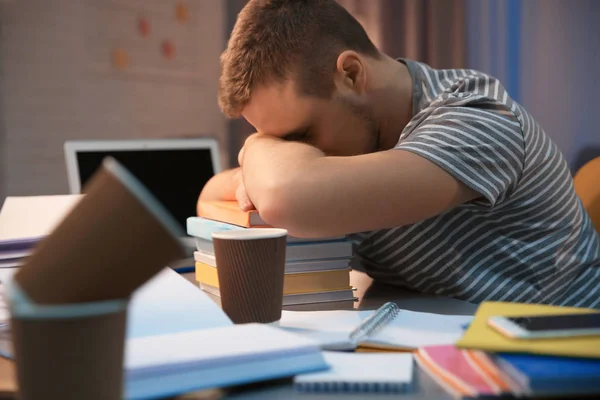 Estudante cansado dormindo à mesa dentro de casa — Fotografia de Stock