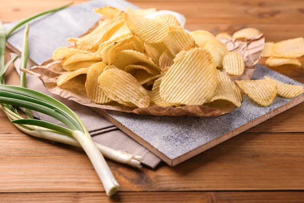 Potato chips on wooden board — Stock Photo, Image