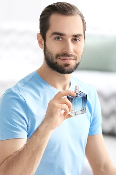 Hombre guapo con botella de perfume — Foto de Stock