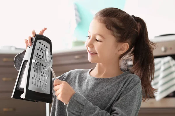 Linda niña tocando música con rallador y cuchara en la cocina — Foto de Stock