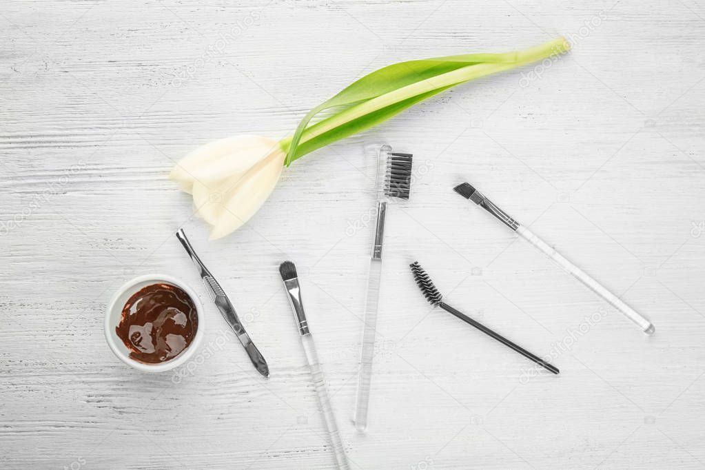 Set of tools for eyebrow dyeing and correction on wooden background