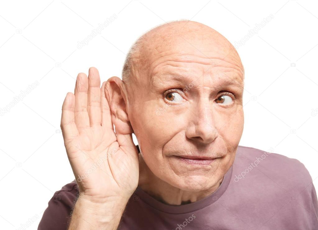 Elderly man with hearing problem on white background