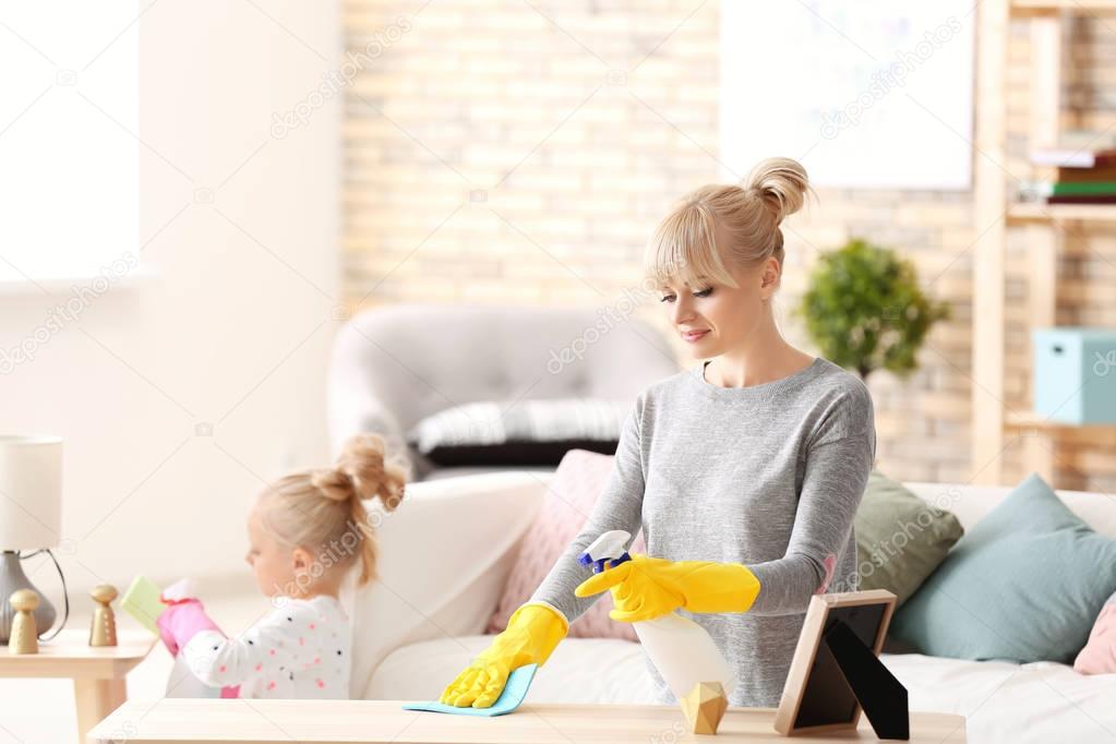 Little girl and her mother cleaning up at home