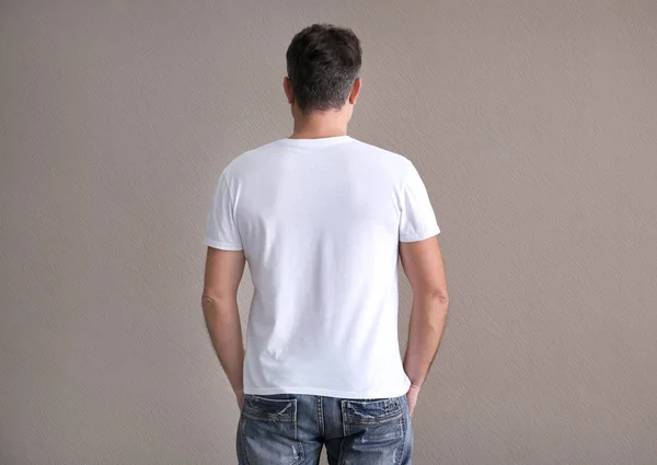 Mannen i färg t-shirt på ljus bakgrund. Mockup för design — Stockfoto