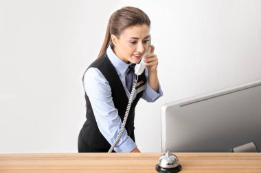 Kadın resepsiyonist otel telefonda konuşuyor
