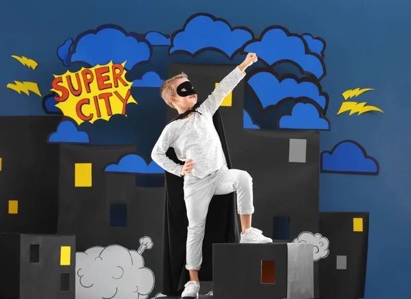 Cute boy as superhero against decoration. Comic strip city theme