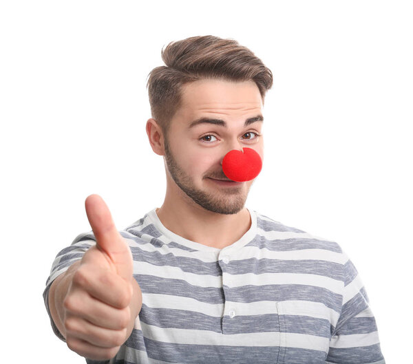 Young man with red clown nose on white background. April fool's day celebration