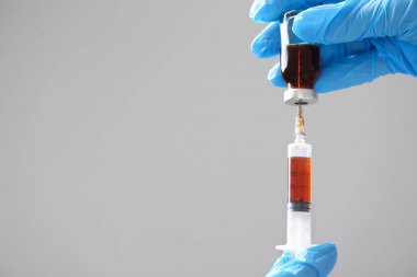 Doktor elinde şırınga tutuyor.