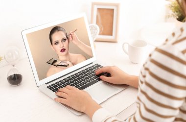 Profesyonel makyaj sanatçısı Masadaki laptop için çevrimiçi eğitim izlerken kadın