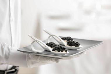 Garson holding tabak meze ile