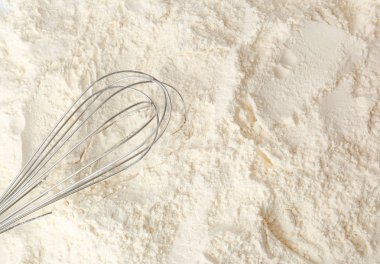 Metal whisk on white wheat flour clipart