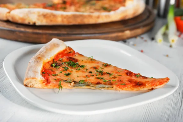 Piatto con fetta di pizza sul tavolo. Fresco dal forno — Foto Stock