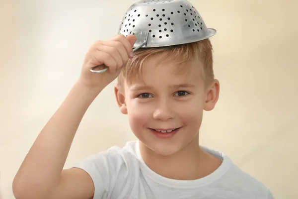 Lindo niño jugando con colador sobre fondo borroso —  Fotos de Stock