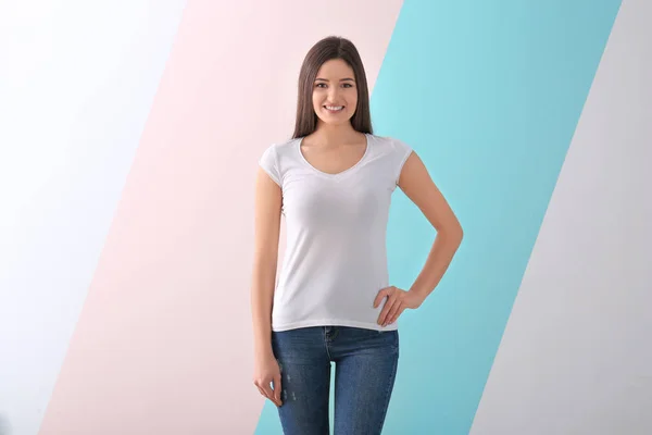 Mulher nova na camiseta elegante no fundo de cor. Mockup para design — Fotografia de Stock