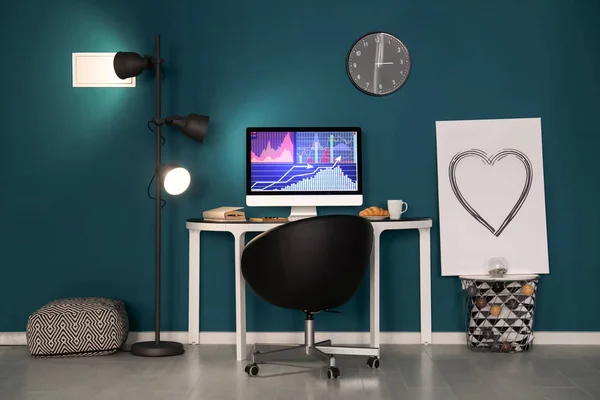 Удобное домашнее рабочее место с компьютером на столе напротив цветной стены — стоковое фото