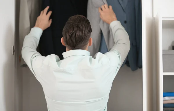 Hombre recogiendo chaqueta de armario . — Foto de Stock