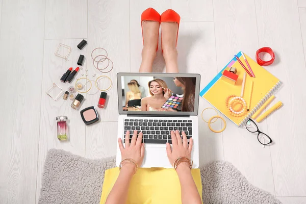 Frau sitzt mit Laptop auf dem Boden und beobachtet Online-Training für professionelle Maskenbildner — Stockfoto