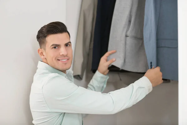 Man picking jacket from closet. — Stock Photo, Image