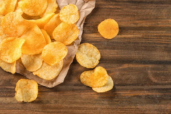Potato chips on wooden table — Stock Photo, Image