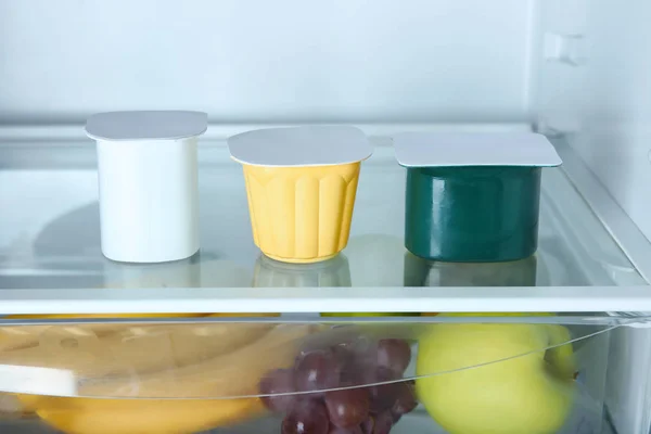 Gelas plastik dengan yogurt di kulkas — Stok Foto