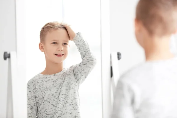 Χαριτωμένο μικρό αγόρι που βλέπει τον εαυτό του στον καθρέφτη σε εσωτερικούς χώρους — Φωτογραφία Αρχείου