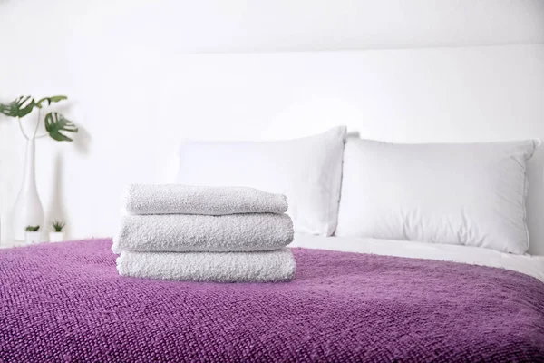 Удобная кровать со сложенными полотенцами в интерьере номера — стоковое фото