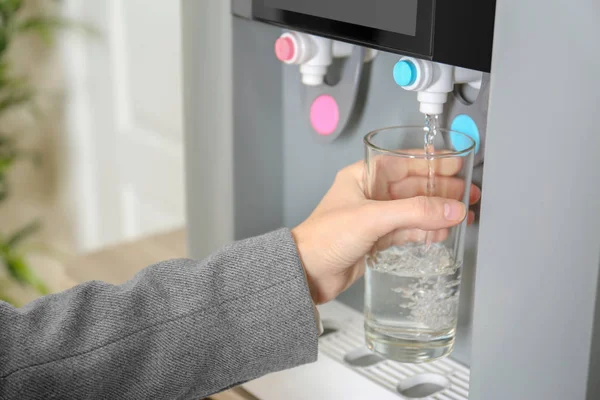 Donna che riempie il vetro dal refrigeratore d'acqua, primo piano — Foto Stock