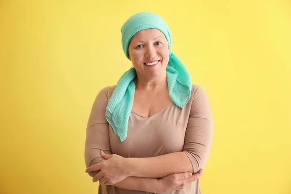Зрелая женщина с раком в платке на цветном фоне — стоковое фото