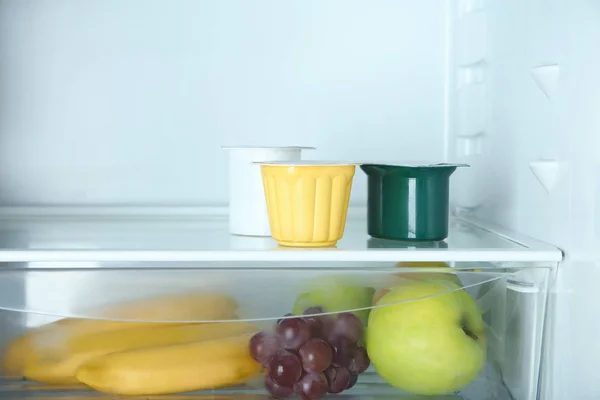 Vasos de plástico con yogur en nevera —  Fotos de Stock