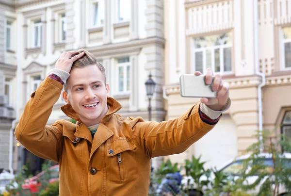 Jovem bonito homem tomando selfie ao ar livre — Fotografia de Stock