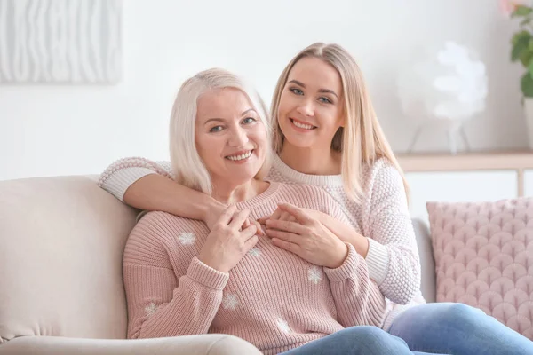 Jeune fille et mère assise sur le canapé à la maison — Photo