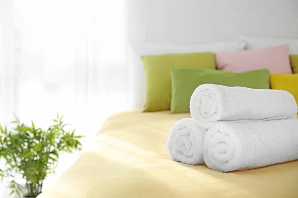 Weiße Handtücher auf dem Bett gerollt — Stockfoto