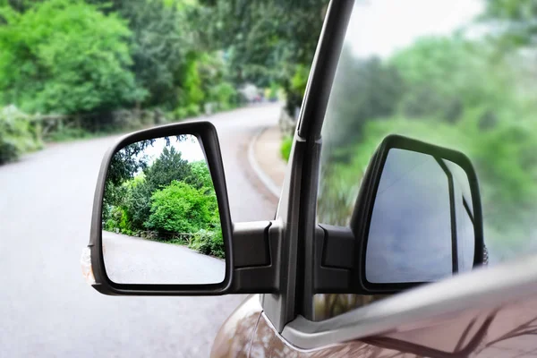 Отражение зеленых деревьев возле дороги в боковом зеркале — стоковое фото
