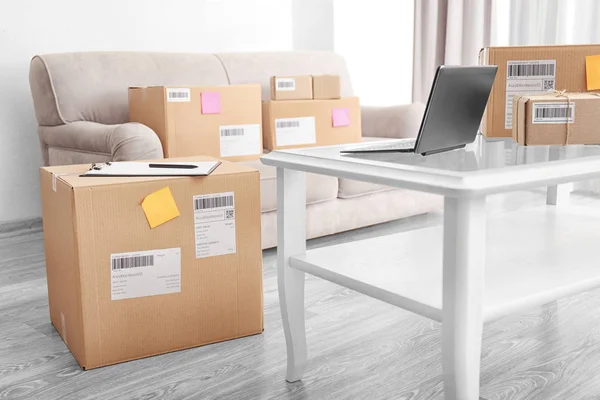 Laptop sul tavolo e pacchi pronti per la spedizione — Foto Stock