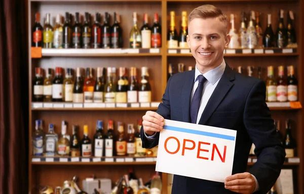 Business owner holding "OPEN" sign in his store — Stock Photo, Image