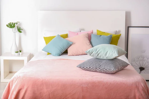 Comfortable bed in light room interior — Stock Photo, Image